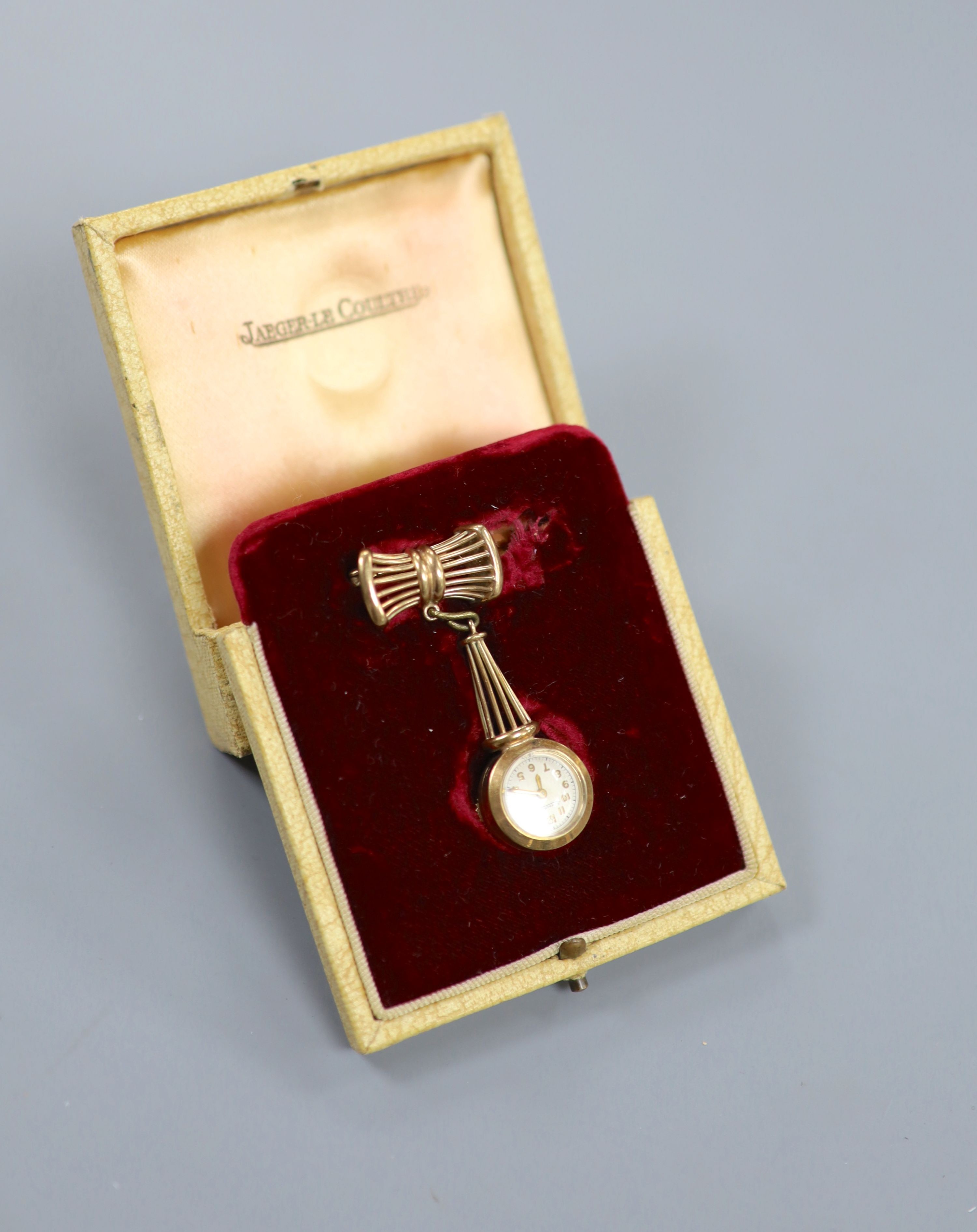 A lady's 9ct gold Jaeger LeCoultre manual back wind pendant watch on a 9ct gold suspension brooch, overall 50mm, gross weight 13.3 grams, case diameter 16mm, in fitted Jaeger LeCoultre box.
